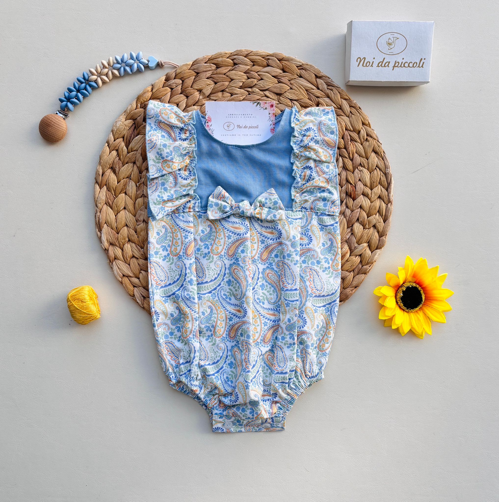 PAGLIACCETTO IN COTONE CON DISEGNINI COLORATI E FIOCCHETTINO CENTRALE CIELO - Noi da piccoli